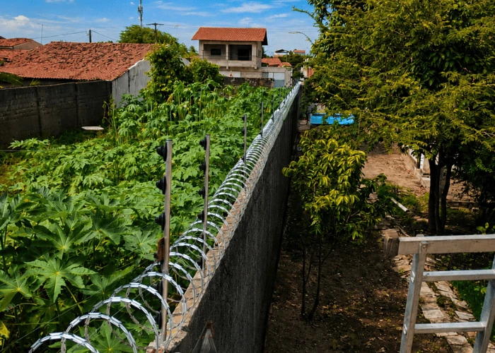 Instalação de cerca concertina em muro residencial realizada pela Força e Luz em Natal RN.