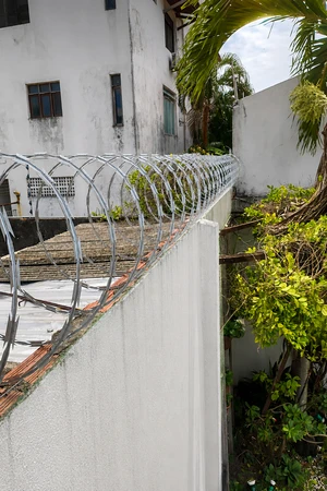 Instalação de cerca concertina 30 cm em Galvalume com alumínio realizada pela Força e Luz em residência no bairro Capim Macio, Natal RN, reforçando a proteção perimetral do imóvel.